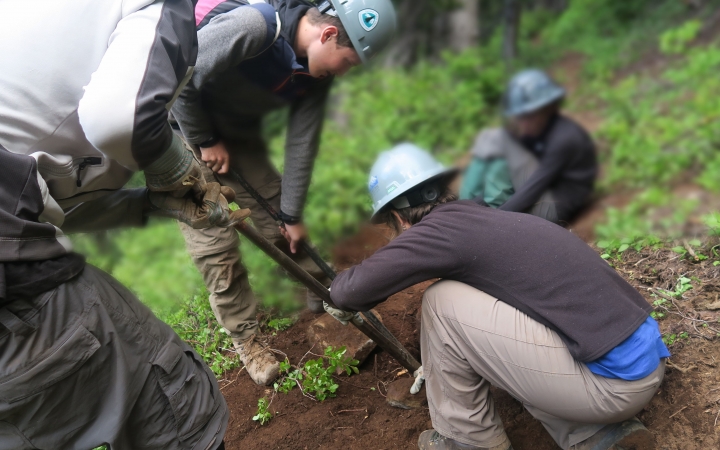 students use gardening tools during a service day with outward bound